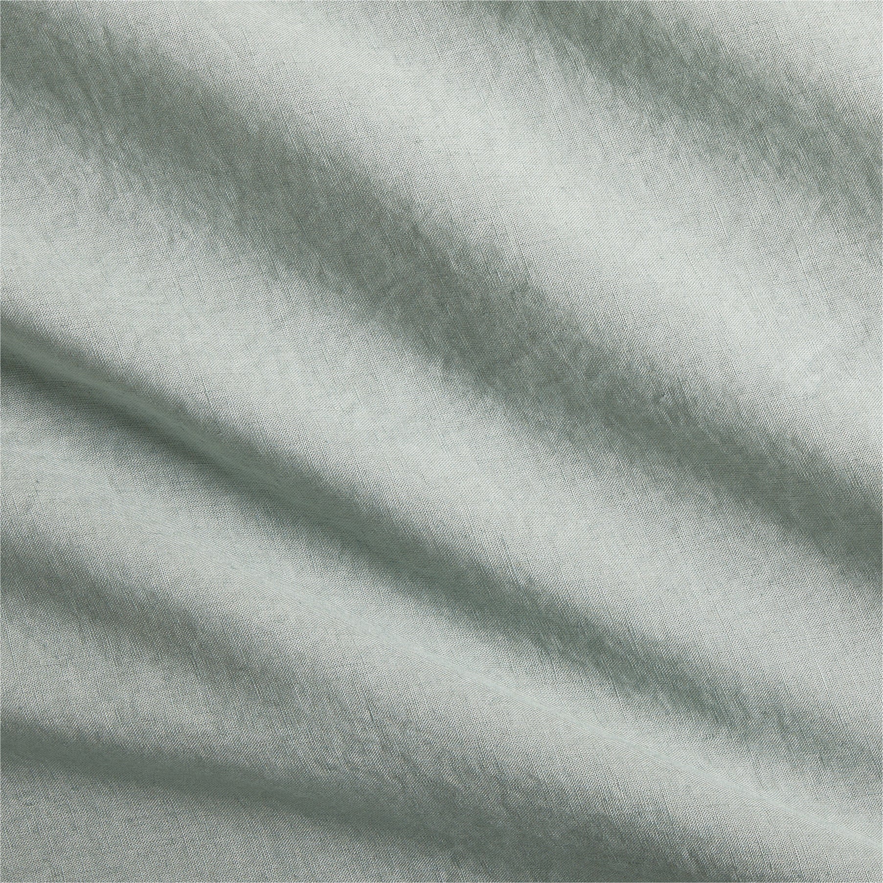 Sage green washed Italian linen duvet cover fabric with soft folds.