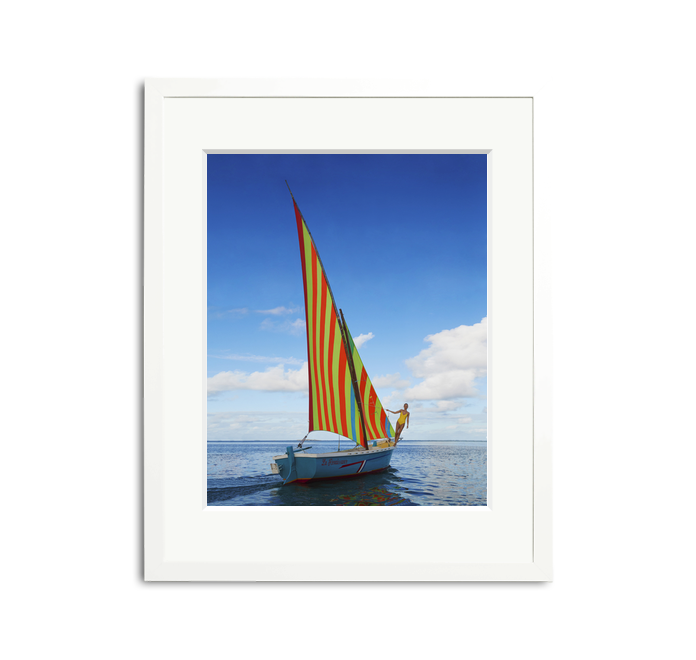 Sailing in Mauritius framed wall art print with a vibrantly striped sailboat on clear waters.