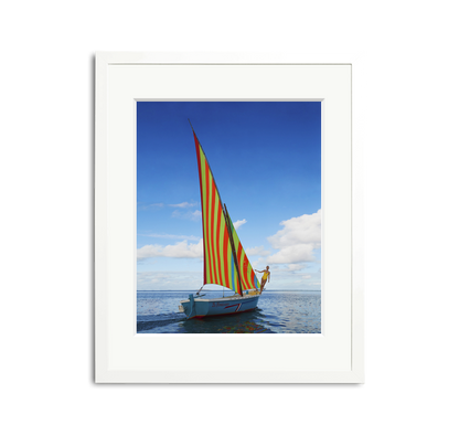 Sailing in Mauritius framed wall art print with a vibrantly striped sailboat on clear waters.
