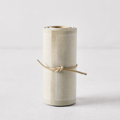 Roll of 50 sand-colored tear-off cotton cocktail napkins, tied with natural twine.
