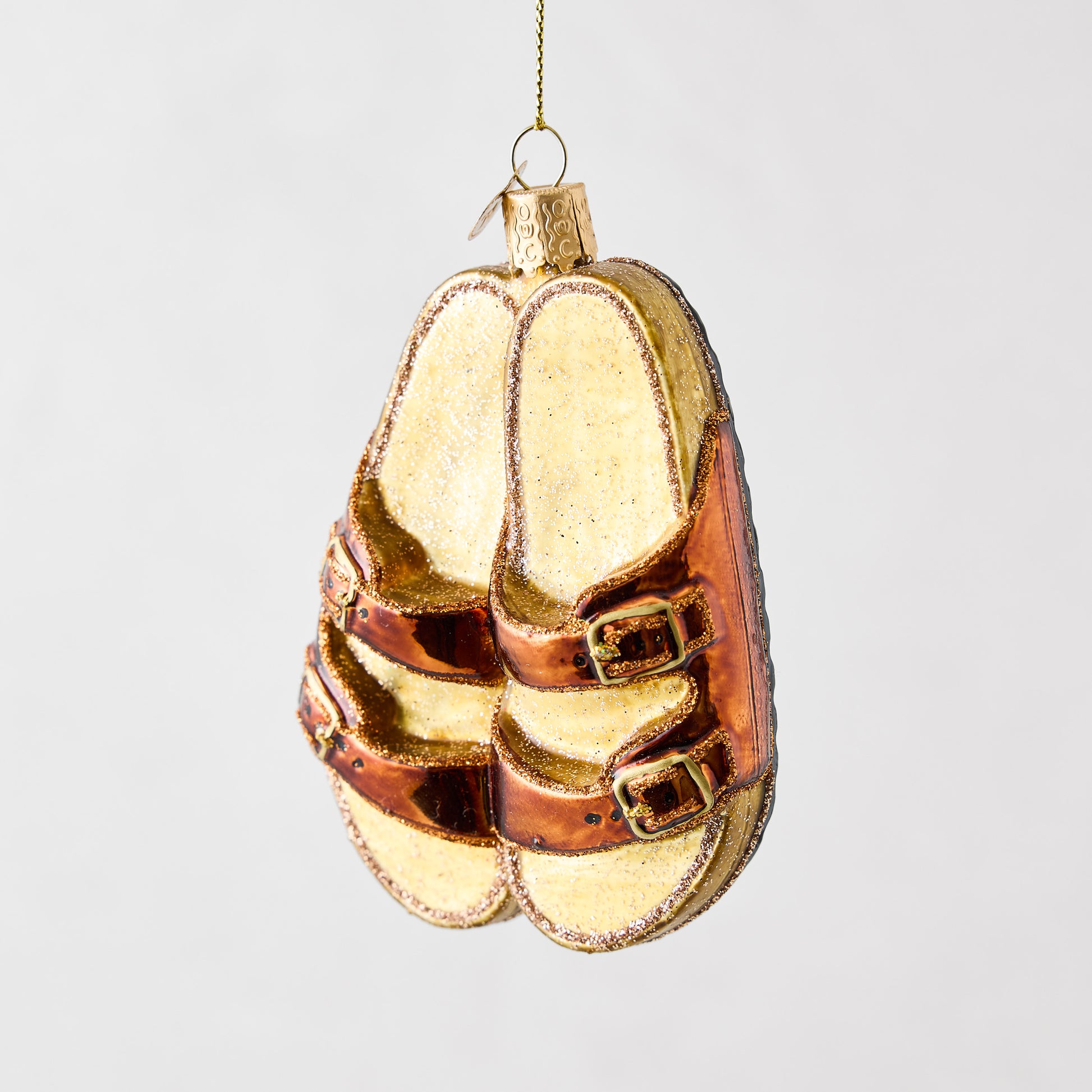 Hand-painted glass and resin sandal ornament in metallic bronze and glittery tan with gold buckles.