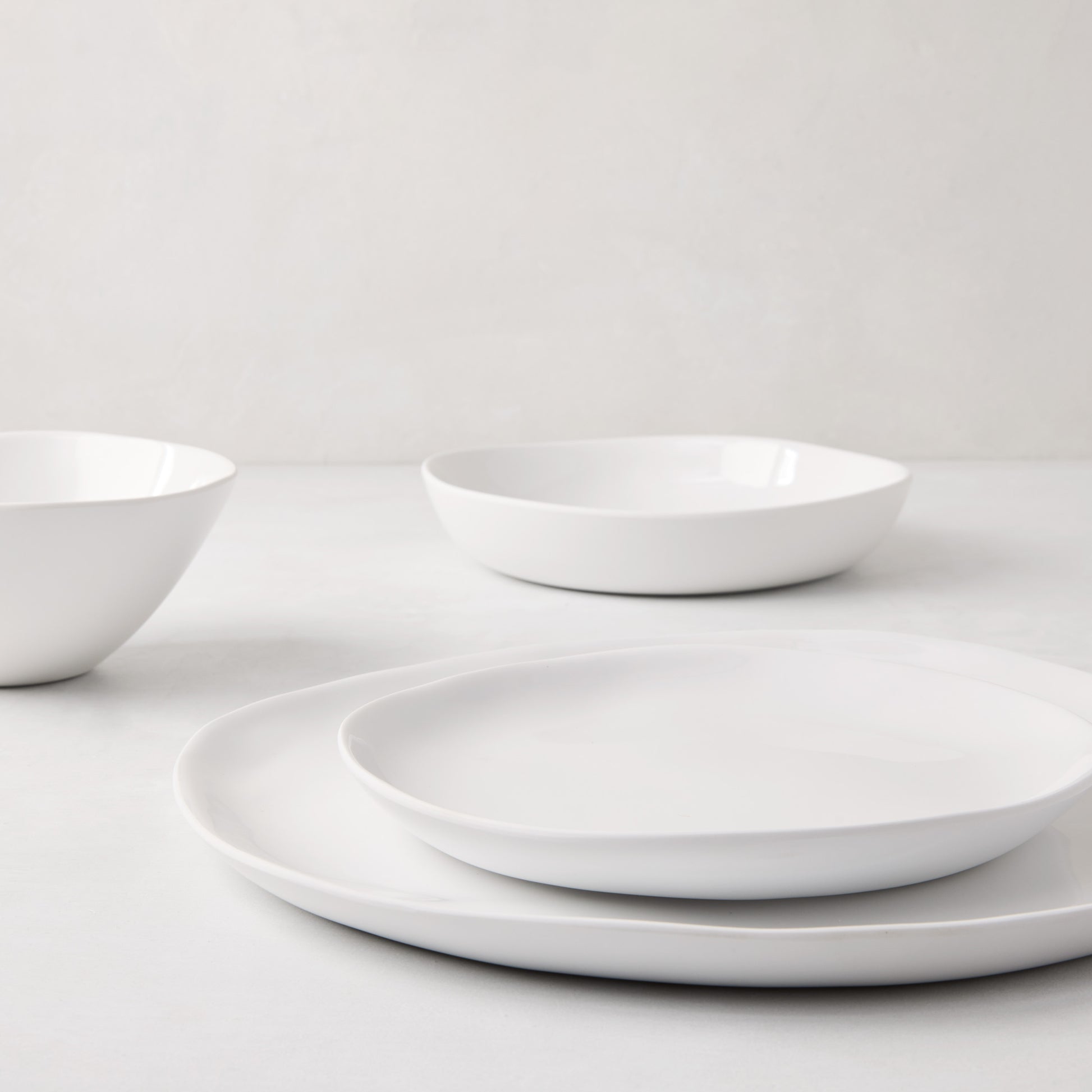 Sandia White 11" melamine dinner plate with organic, hand-thrown-inspired curves and a glossy interior.