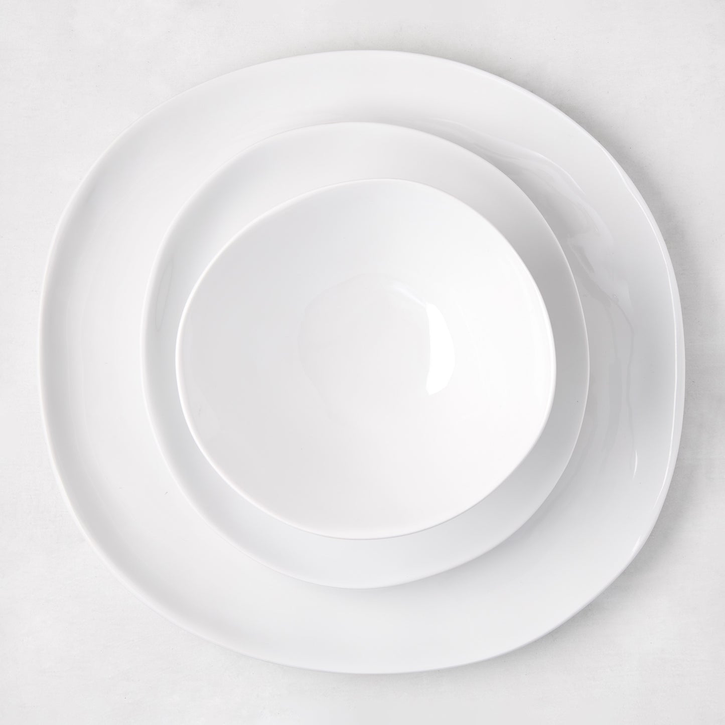 Sandia White 11" melamine dinner plate with organic, hand-thrown-inspired curves, matte exterior, glossy interior.