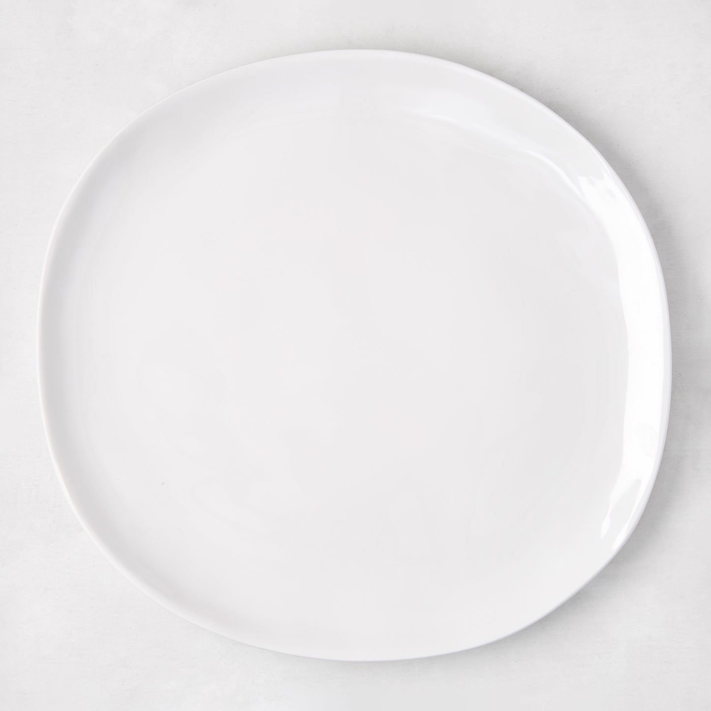 Sandia White 11" round melamine dinner plate with matte exterior and glossy interior.