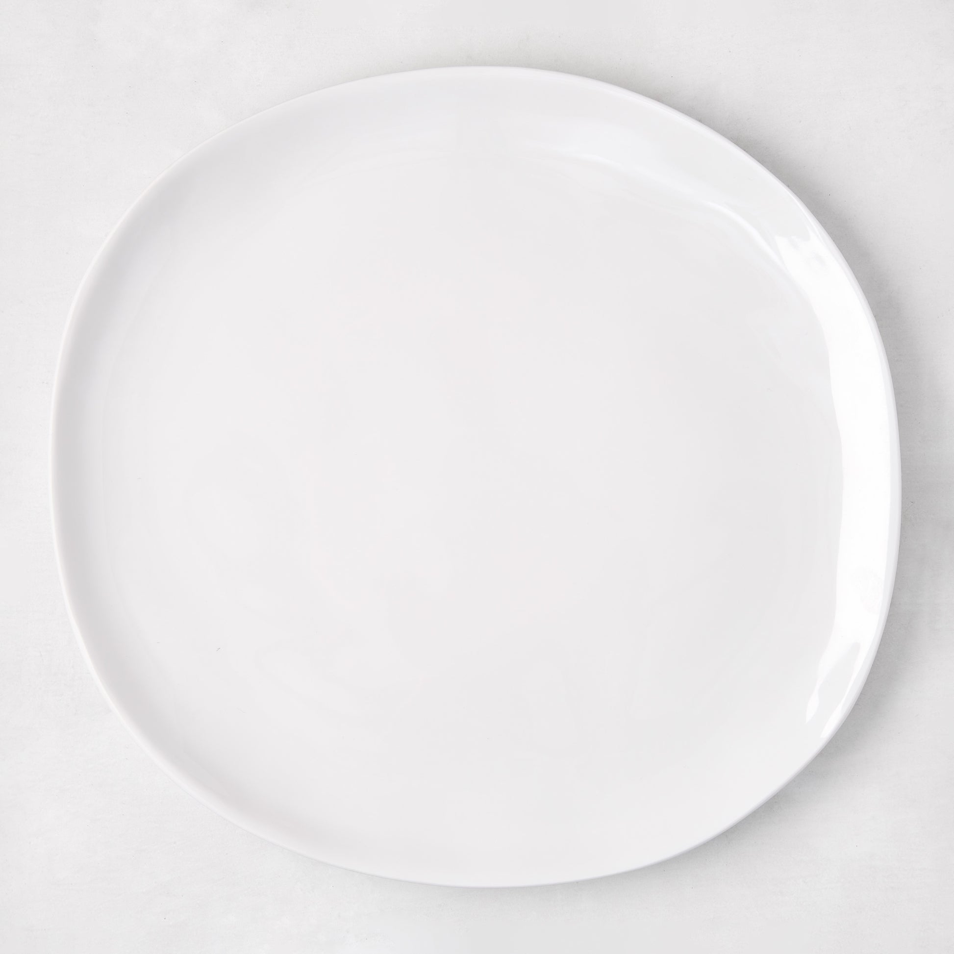 Sandia White 11" round melamine dinner plate with matte exterior and glossy interior.