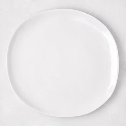 Sandia White 11" round melamine dinner plate with matte exterior and glossy interior.