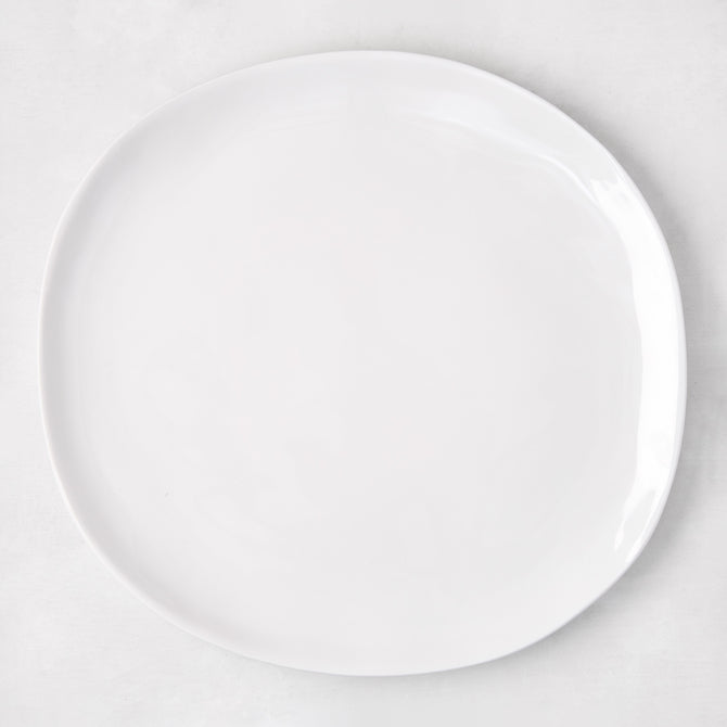 Sandia White 11" round melamine dinner plate with matte exterior and glossy interior.