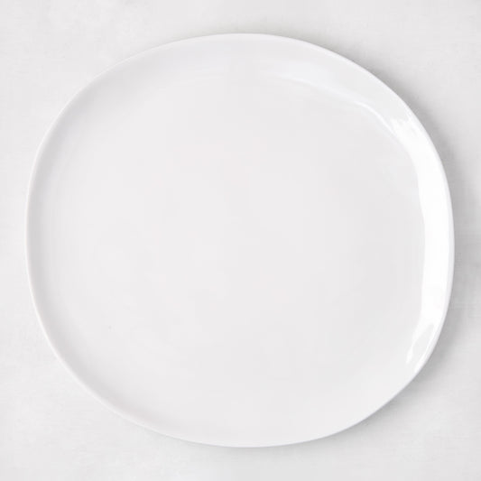 Sandia White 11" round melamine dinner plate with matte exterior and glossy interior.