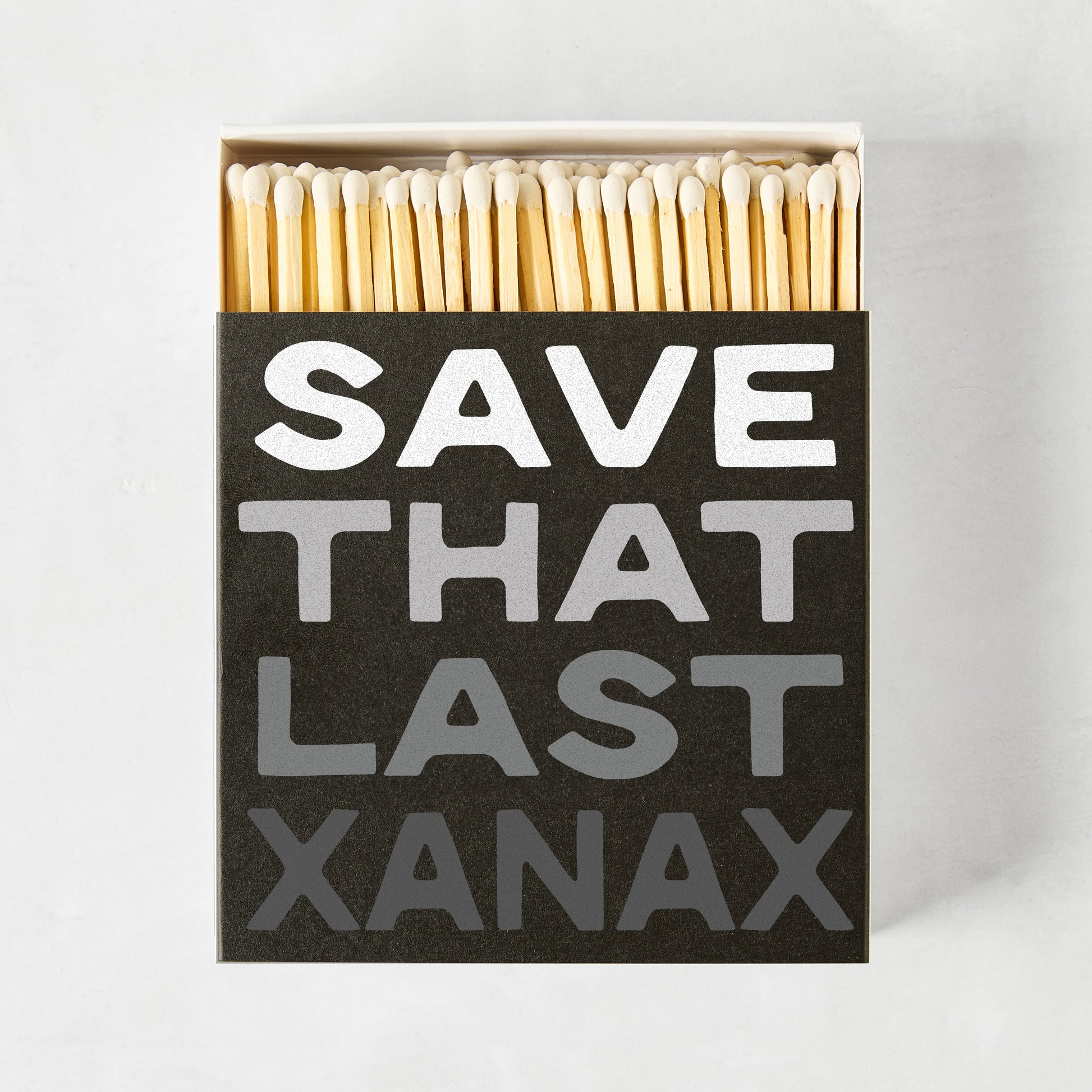 Black oversized matchbox with "SAVE THAT LAST XANAX" in white and gray text, filled with long wooden matches.
