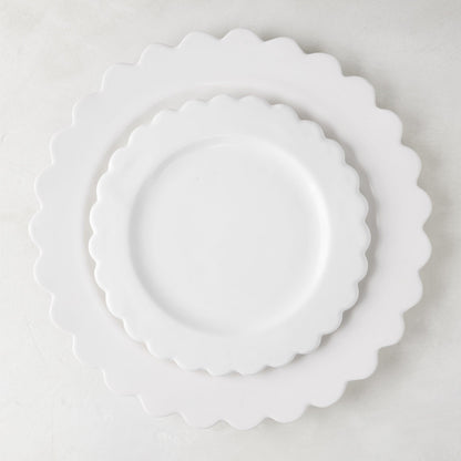White ceramic scalloped dinner plate (12") layered with a smaller scalloped salad plate.