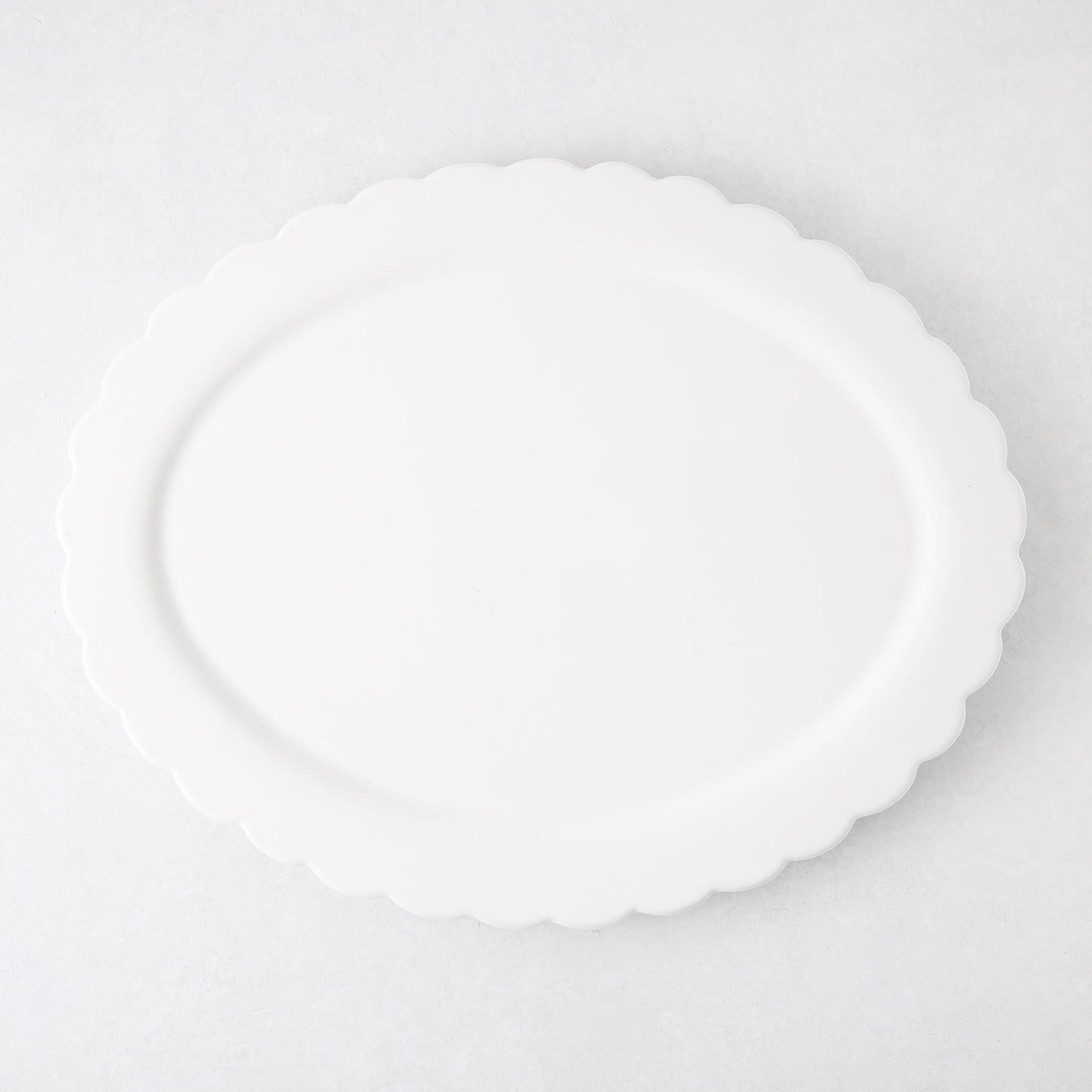 White ceramic Scallop Oval Serving Platter, 17.72"L x 14.17"W, with a subtle scalloped edge.