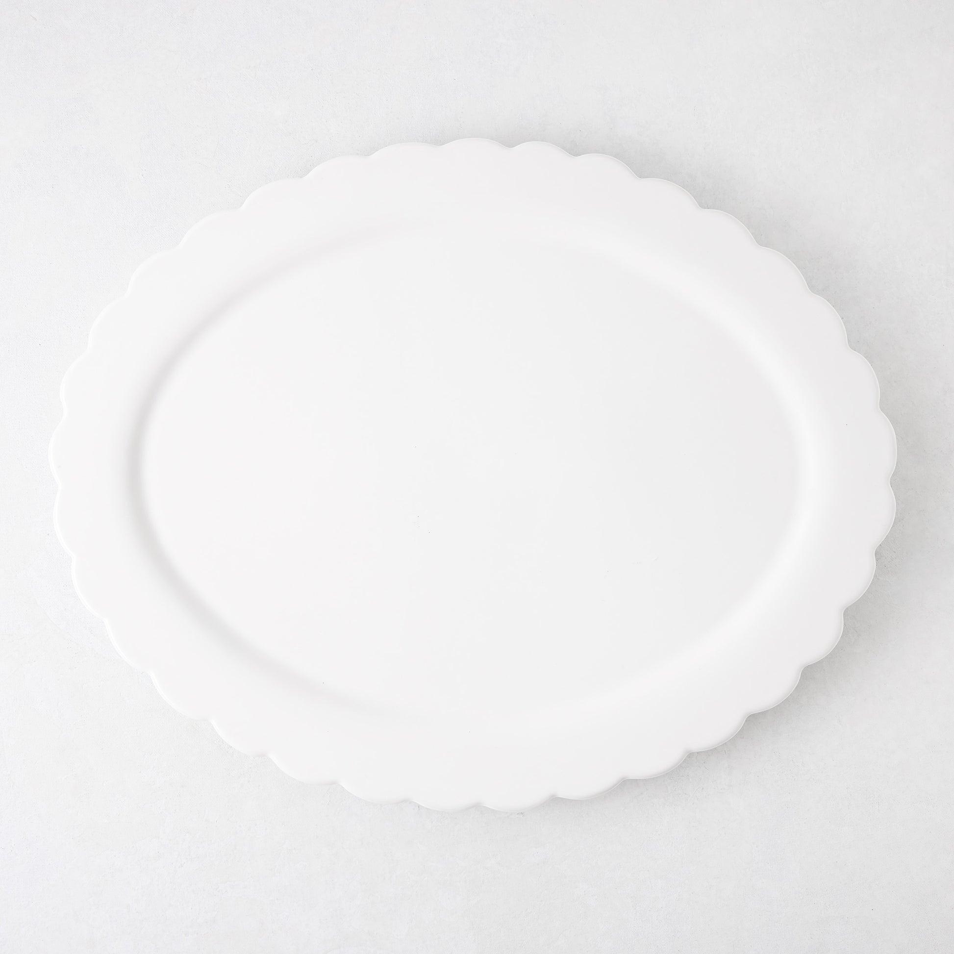 White ceramic Scallop Oval Serving Platter, 17.72"L x 14.17"W, with a subtle scalloped edge.