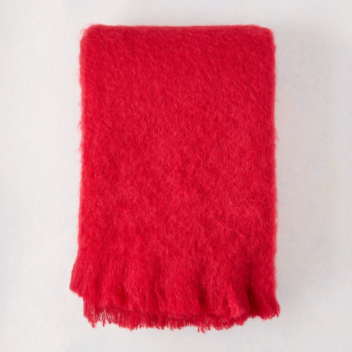 Scarlet Red Solid Mohair Throw Blanket, folded, with fringed edges.