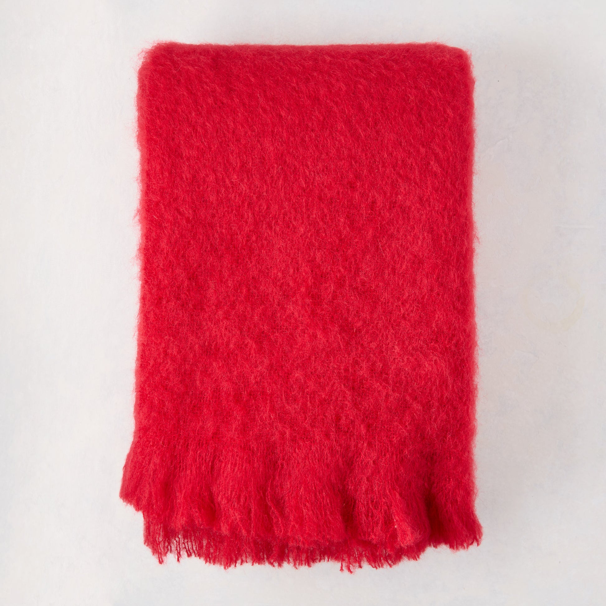 Scarlet Red Solid Mohair Throw Blanket, folded, with fringed edges.