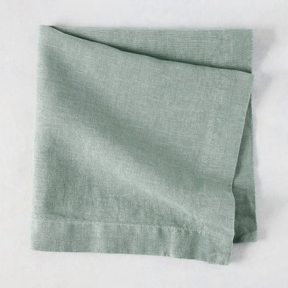 Sea Glass HG Signature hand-dyed linen napkin, folded, showing soft blue-aqua color and natural texture.