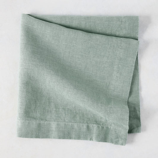Sea Glass HG Signature hand-dyed linen napkin, folded, showing soft blue-aqua color and natural texture.