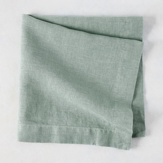Sea Glass HG Signature hand-dyed linen napkin, folded, showing soft blue-aqua color and natural texture.