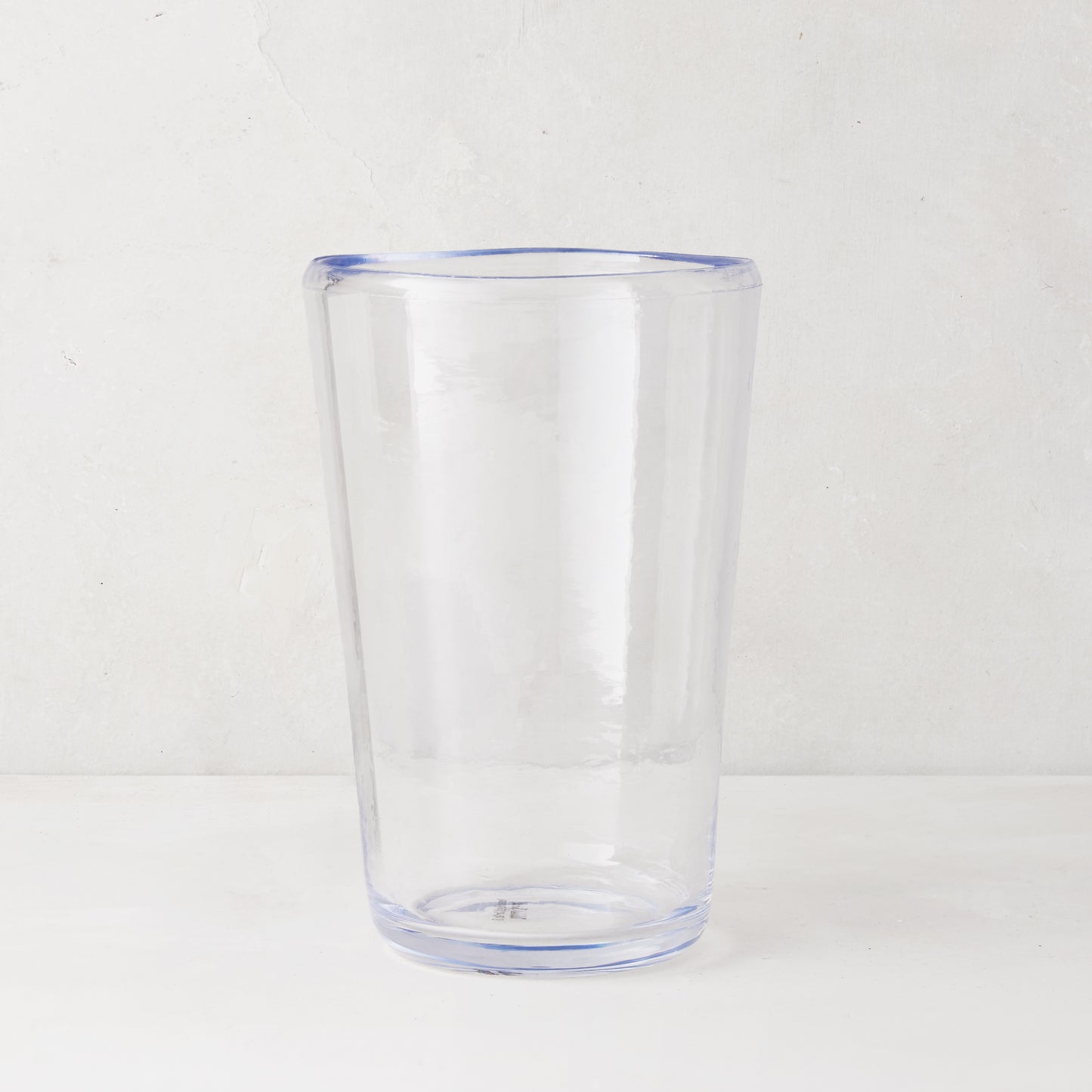Clear acrylic Seadrift highball glass with a subtle blue rim and base, 19oz.