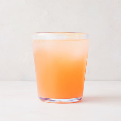 Acrylic Seadrift Old Fashioned Glass with a peach-colored drink and ice, inspired by Mexican glassware.