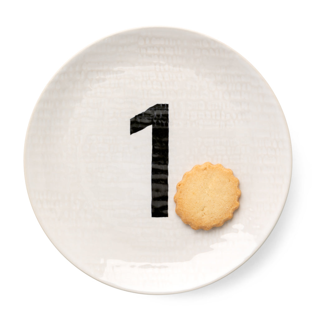 Cream ceramic salad plate with hammered finish, black number 1, and a cookie.