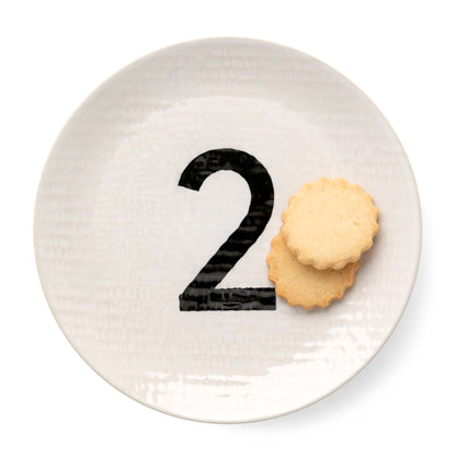 Cream ceramic salad plate with hammered finish, black number 2, and two shortbread cookies.