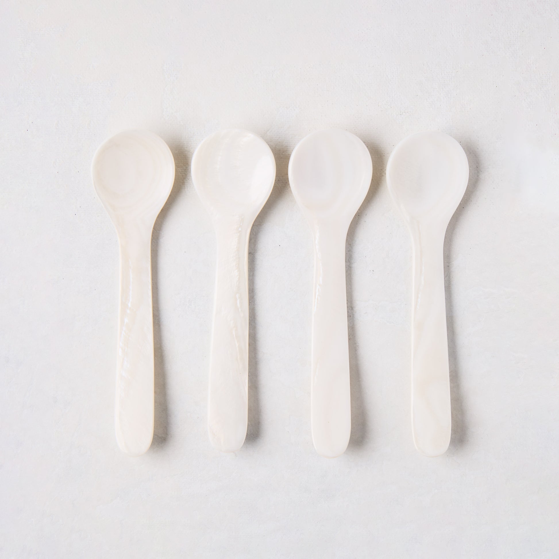 Set of 4 hand-carved Mother of Pearl caviar spoons, 3.25"L, with unique natural variations.