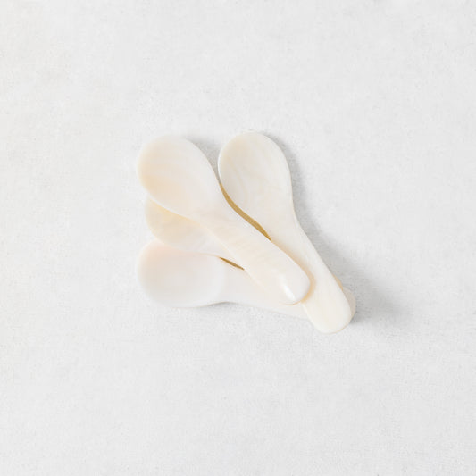 Set of four hand-carved 3.25-inch Mother of Pearl caviar spoons with iridescent white finish.