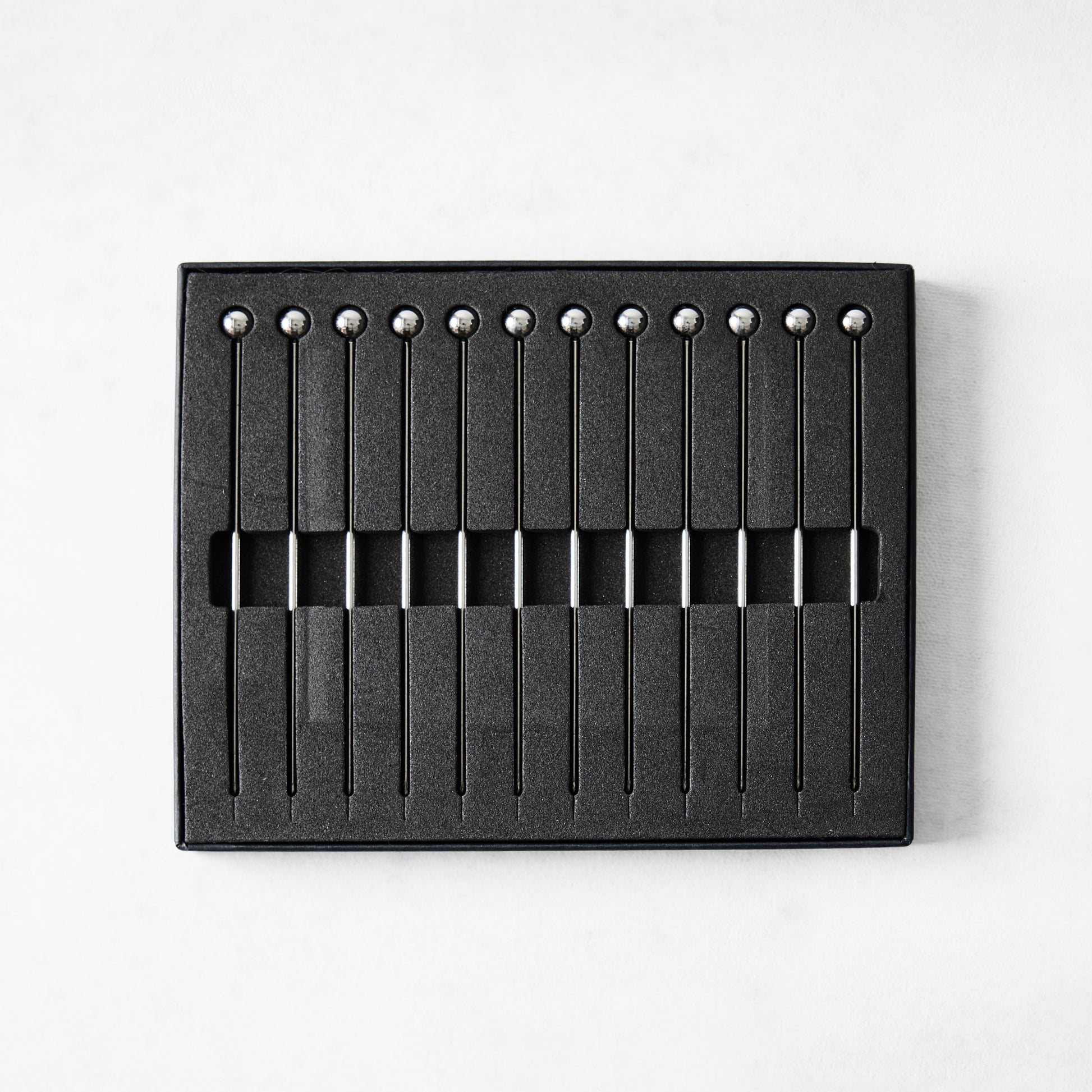 Set of 12 short 4" stainless steel cocktail picks with ball tops, displayed in a black box.