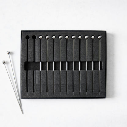 Set of 12 short 4" stainless steel cocktail picks with ball tops, in black foam packaging.