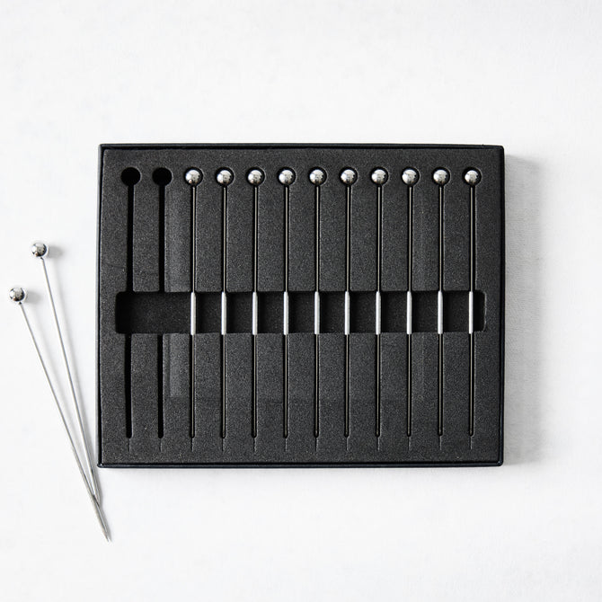 Set of 12 short 4" stainless steel cocktail picks with ball tops, in black foam packaging.
