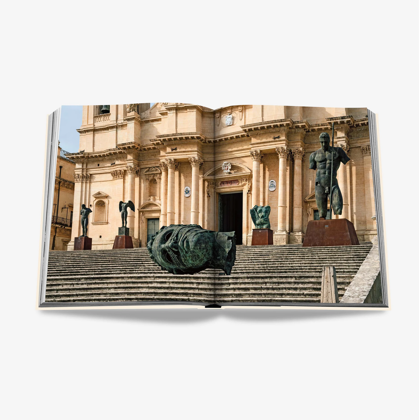 Open "Sicily Honor" book displaying a photo of ancient bronze statues and a large stone building.