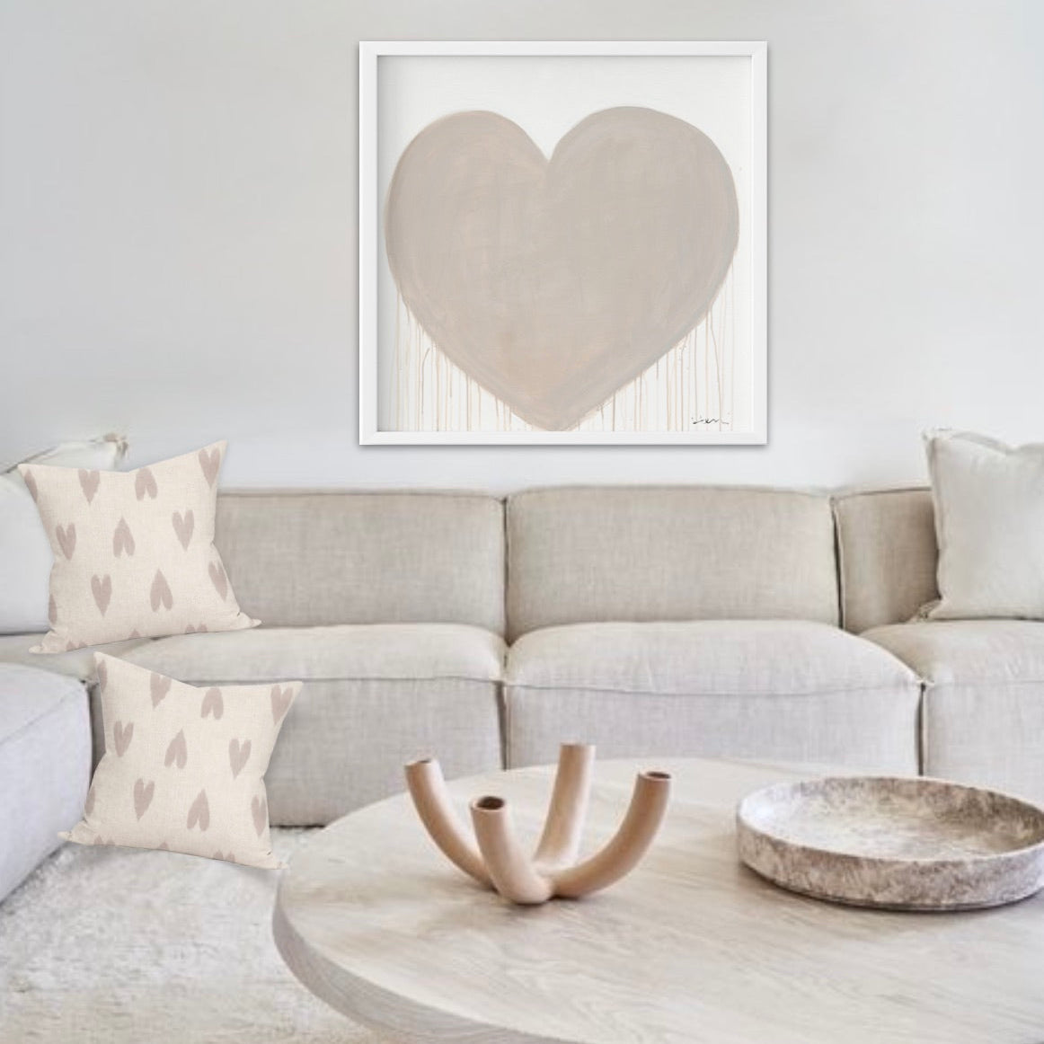 Kerri Rosenthal Simple Kinda Love art print: neutral beige tan drippy heart on white, framed above a sofa.