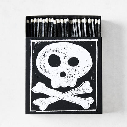 Black box of oversized matches featuring a white skull and crossbones print with black-tipped 4-inch matchsticks.