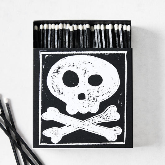 Black box of oversized matches featuring a white skull and crossbones design with black matchsticks and white tips.