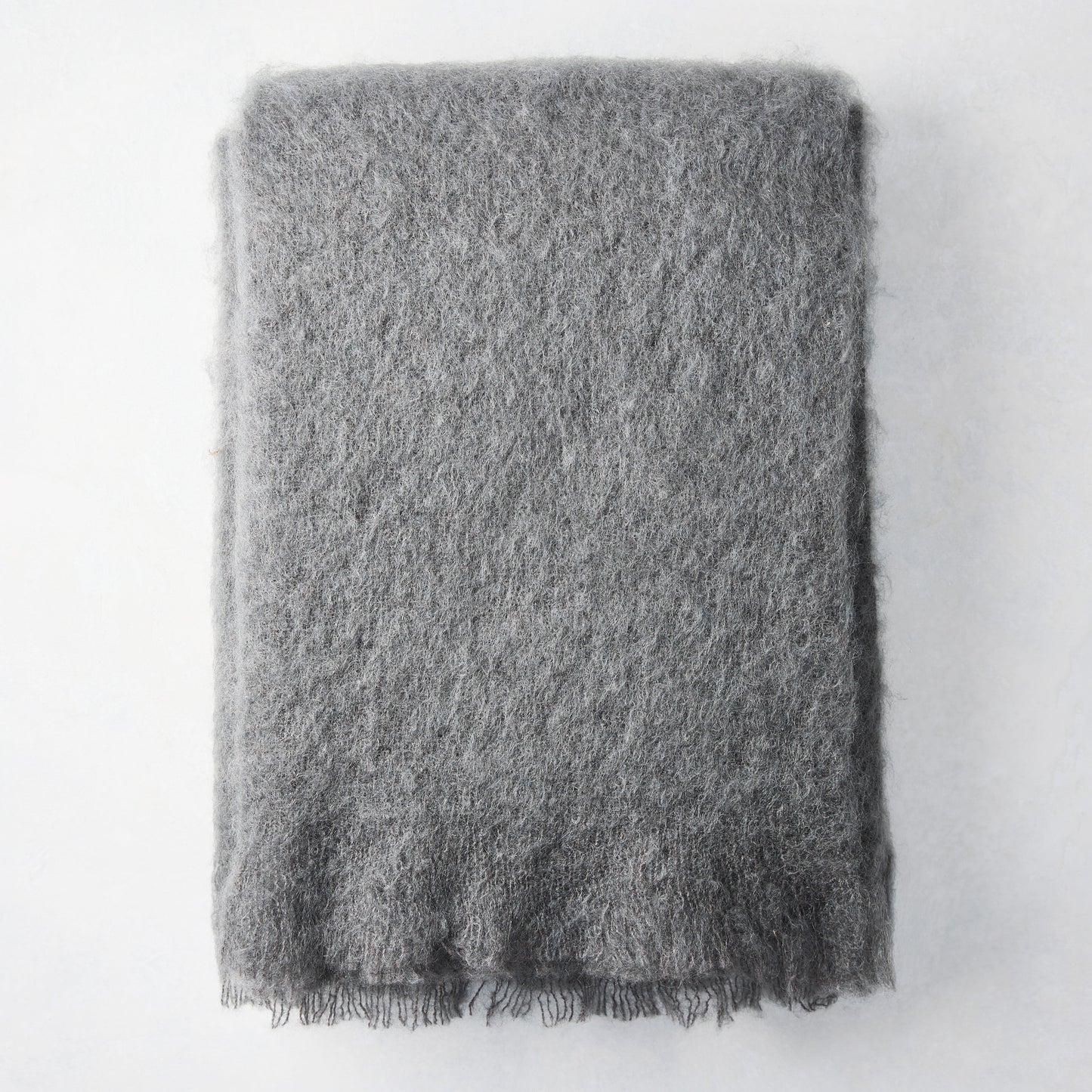 Folded slate grey mohair throw blanket, 72"L x 51"W, with a soft, shaggy texture and fringed edge.