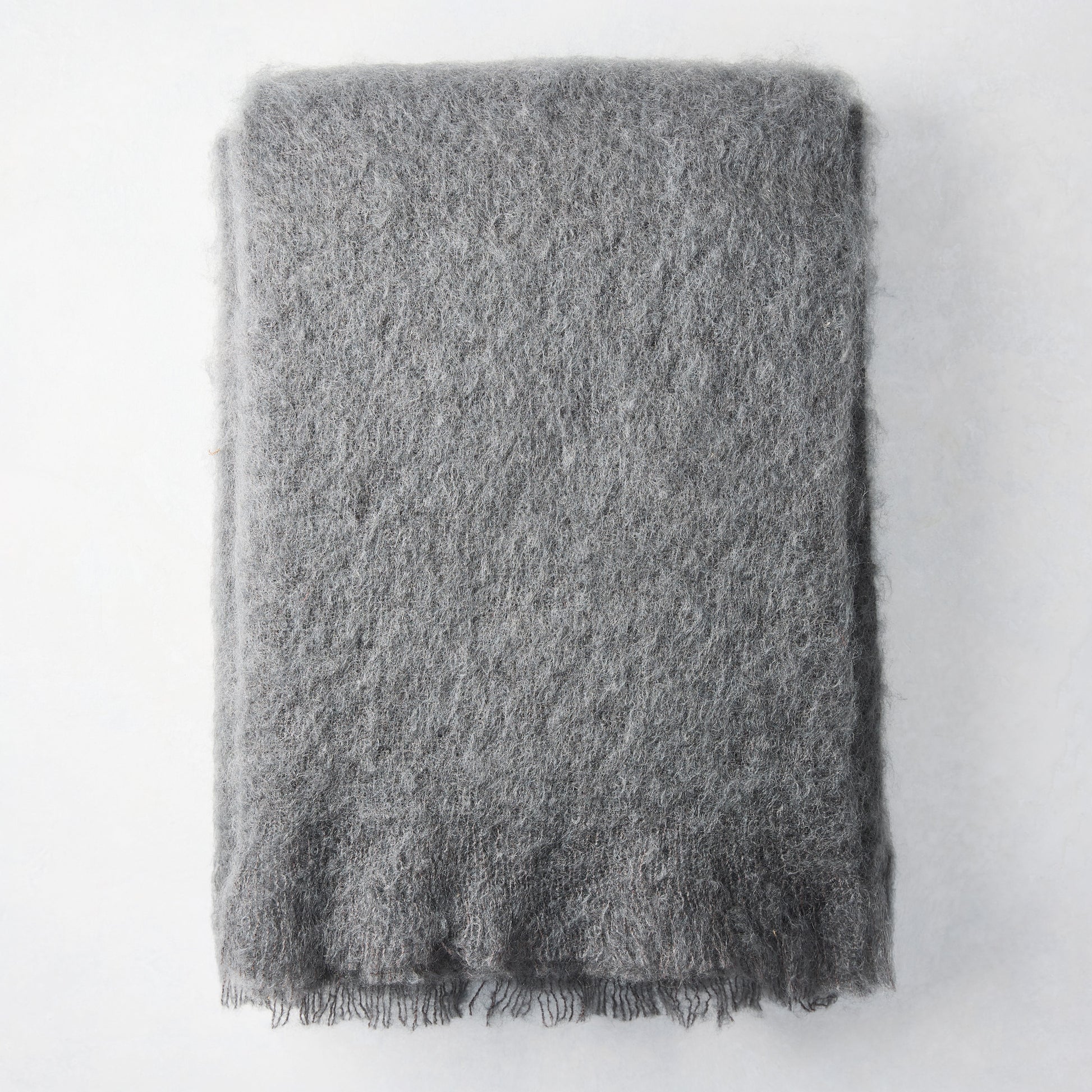 Folded slate grey mohair throw blanket, 72"L x 51"W, with a soft, shaggy texture and fringed edge.