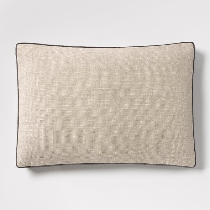 Linen lumbar pillow with a textured beige fabric and dark grey piping, 20"L x 14"H.