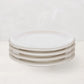 Stack of four white HG Appetizer 6.5" earthenware small plates with a low lip.