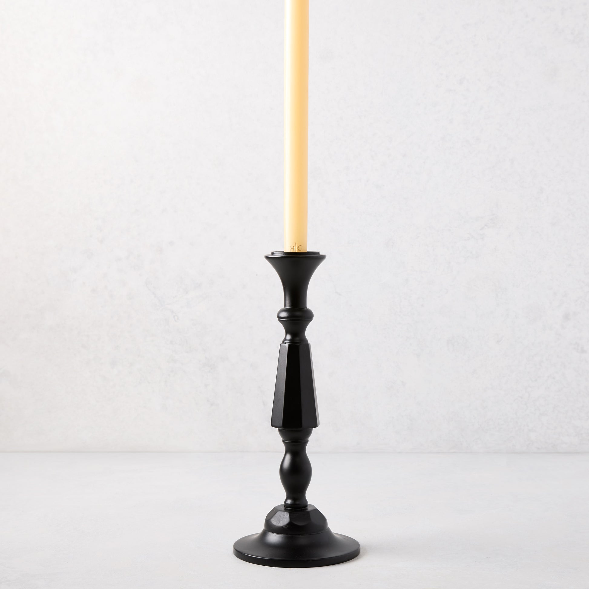 Small black lacquer Georgian candlestick with a cream taper candle.