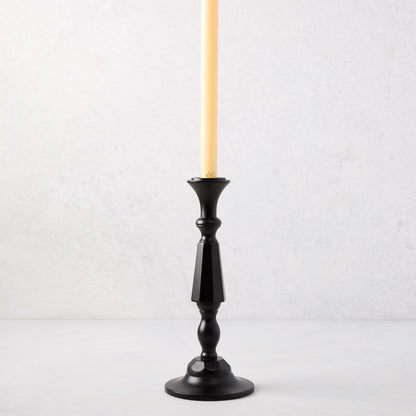 Small black lacquer Georgian candlestick with a cream taper candle.