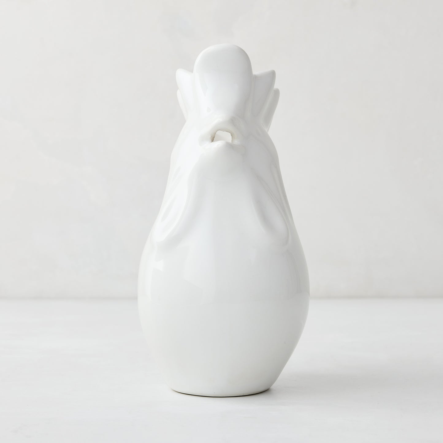 White ceramic rooster pitcher, 6.75"H, with a glossy glaze and detailed head.