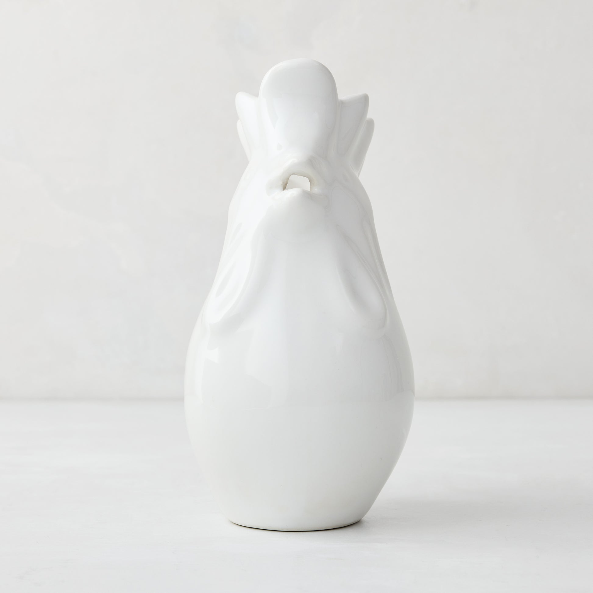 White ceramic rooster pitcher, 6.75"H, with a glossy glaze and detailed head.