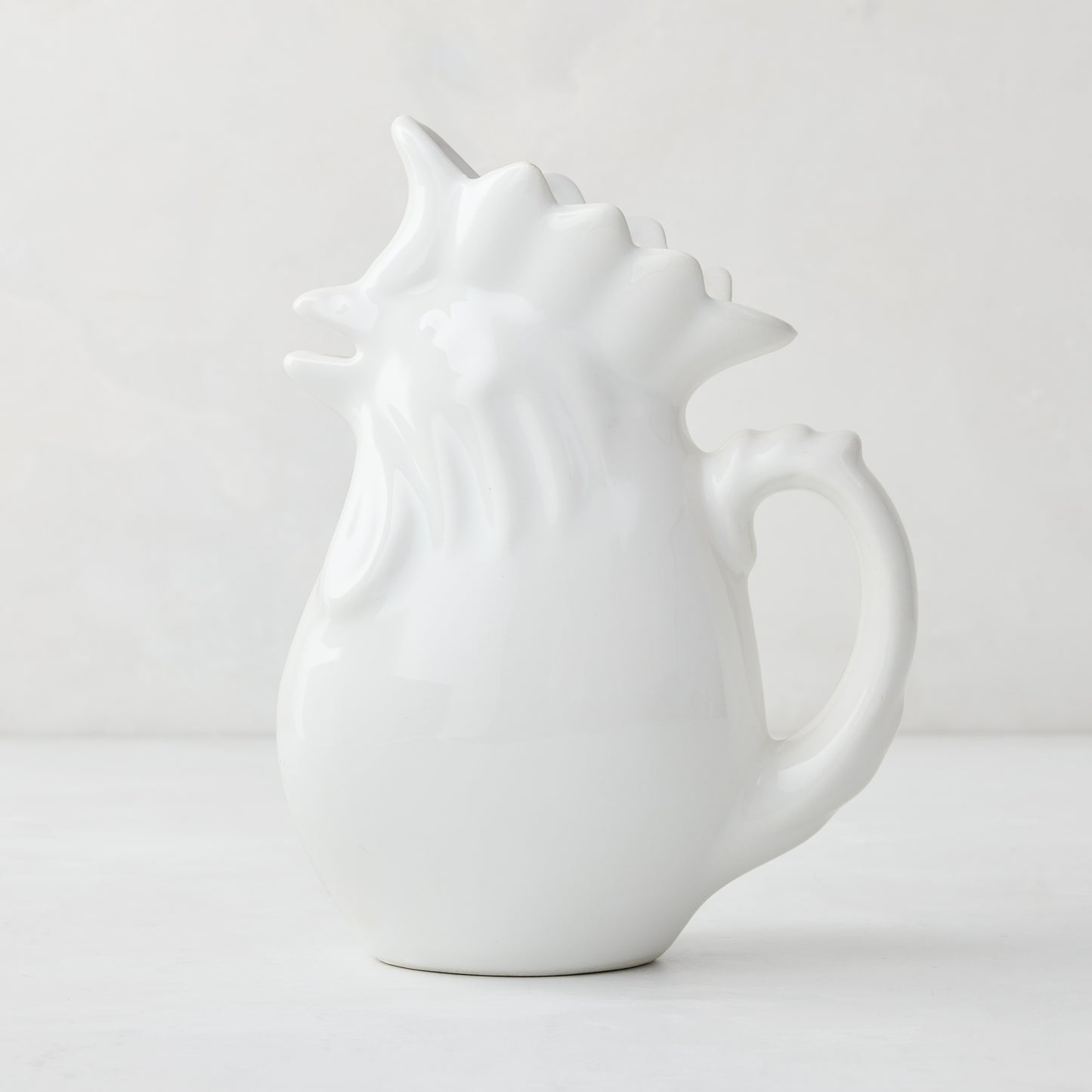 White ceramic rooster pitcher, 6.75"H, with a glossy glaze and detailed comb.