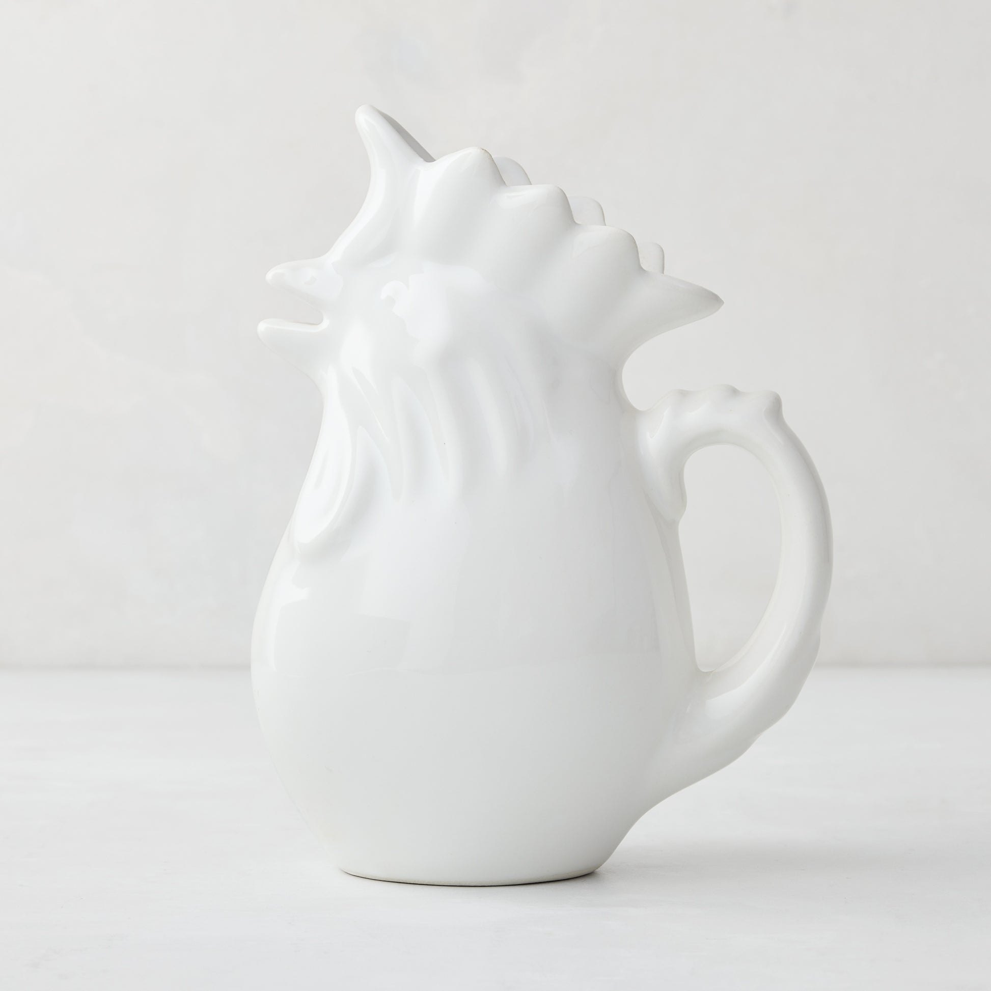 White ceramic rooster pitcher, 6.75"H, with a glossy glaze and detailed comb.