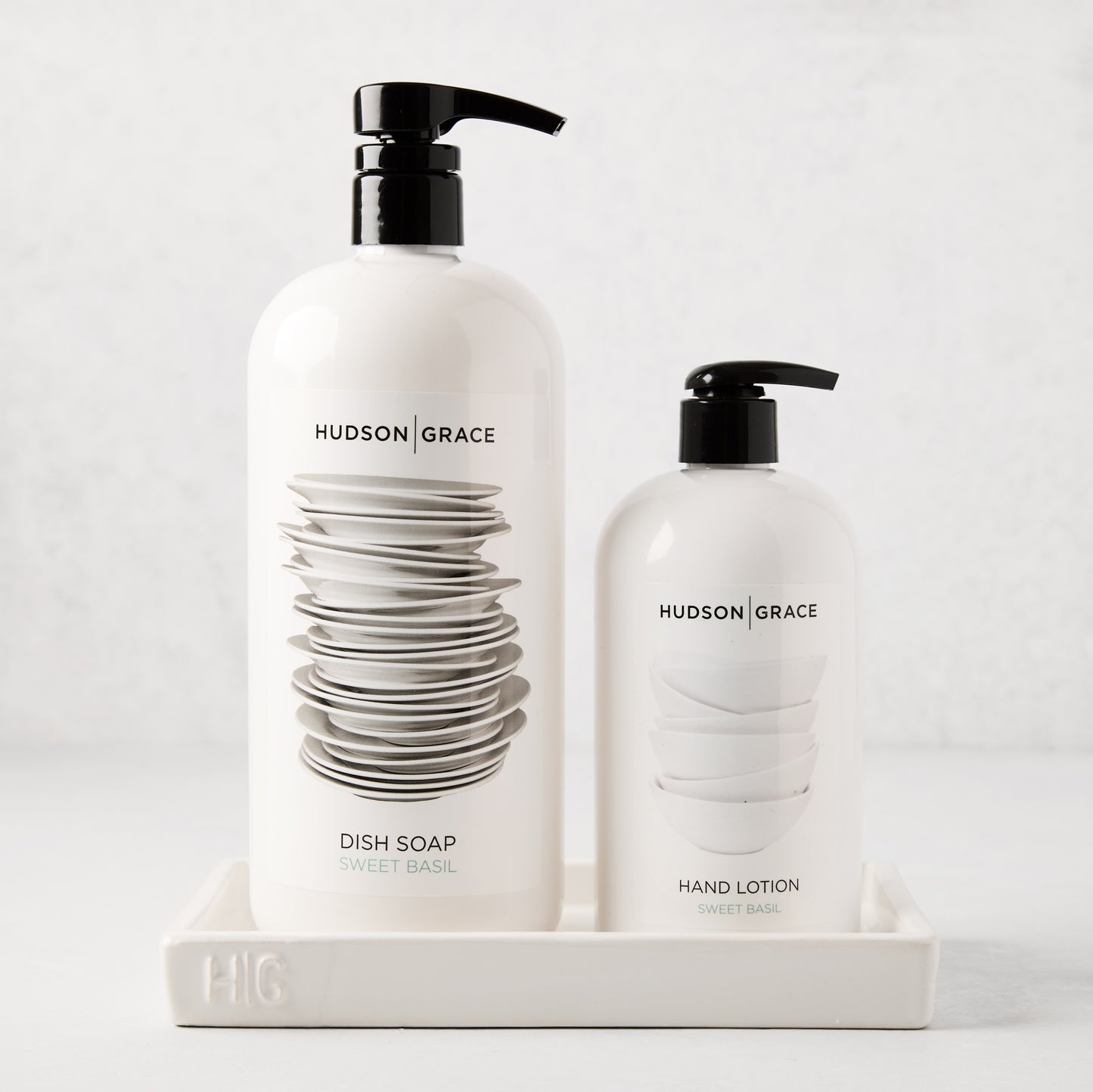 White ceramic HG Everyday Tray holding two Hudson Grace cleaning bottles.
