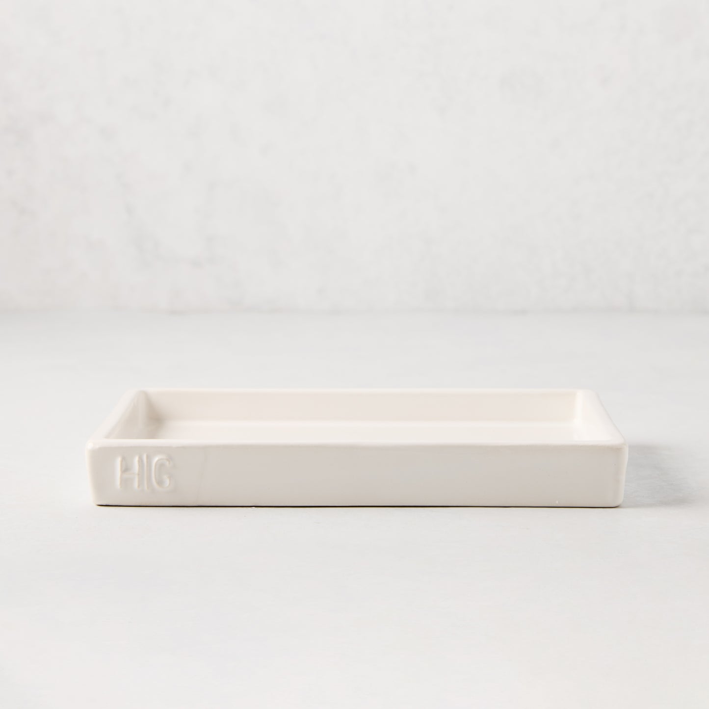 White ceramic rectangular tray with an understated lip and "HG" monogram.