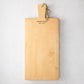 Light wood serving plank with handle, rope loop, and "Hudson Grace Made in Hungary" engraved.