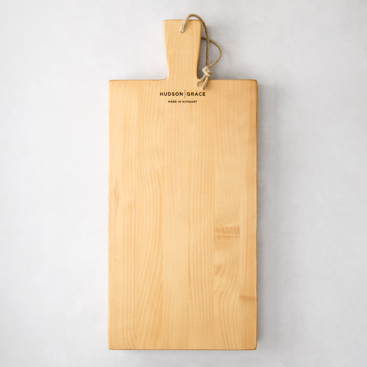 Light wood serving plank with handle, rope loop, and "Hudson Grace Made in Hungary" engraved.