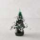 Handblown green glass Christmas tree, 7"H x 5.5"Dia, with clear textured branches and a dark base.