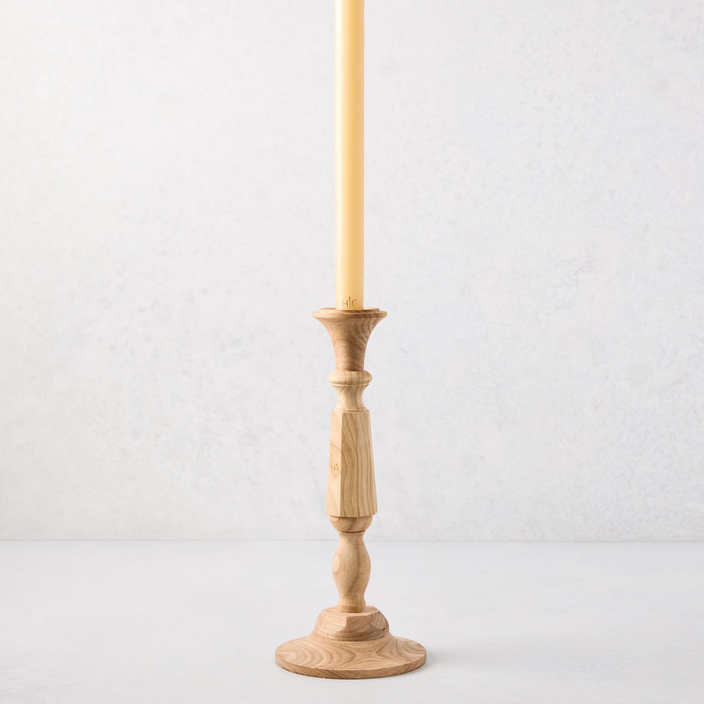 Small natural beechwood Georgian candlestick, 11"H, with a cream taper candle.